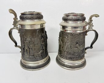 Par de jarras de cerveza alemanas de peltre Munzel Koblenz con escenas de caza.