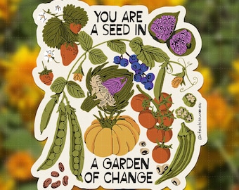 May include: A die-cut sticker featuring an illustration of strawberries, blueberries, peas, an artichoke, a pumpkin, tomatoes, and okra. The text reads YOU ARE A SEED IN A GARDEN OF CHANGE. The design includes green leaves and brown beans on a white background.
