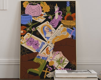 May include: A rectangular art print in a gold frame featuring a black background with illustrations of tarot cards, a pink vase, a cat-shaped candle holder, a bowl of fruit, and hands holding a matchbox labelled Dallas Dandies, all rendered in vibrant colours.