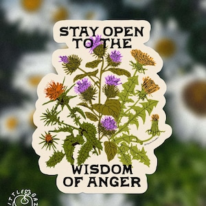 Puede incluir: Una pegatina troquelada con una ilustración botánica de cardos morados y flores de diente de león naranjas con hojas verdes. El texto STAY OPEN TO THE está impreso en negro sobre las flores, y WISDOM OF ANGER está impreso en negro debajo.