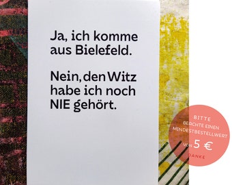 May include: White card with black text that reads "Ja, ich komme aus Bielefeld. Nein, den Witz habe ich noch NIE gehört."  The card also has a red circle with white text that reads "BITTE BEACHTE EINEN MINDESTBESTELLWERT VON 5 € DANKE".