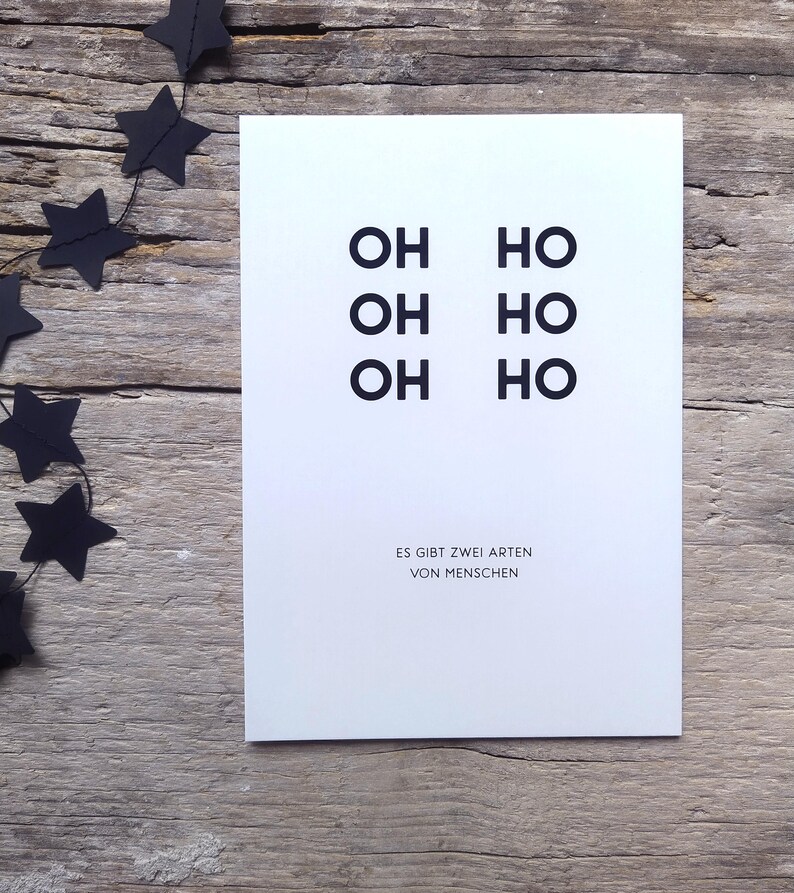 May include: A white rectangular greeting card featuring the black text OH HO, OH HO, OH HO arranged in two columns, with the German text ES GIBT ZWEI ARTEN VON MENSCHEN printed in smaller black capital letters at the bottom of the card.