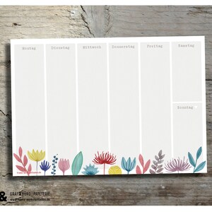 May include: A weekly planner with a floral border. The planner is divided into seven sections for each day of the week: Monday, Tuesday, Wednesday, Thursday, Friday, Saturday, and Sunday. The planner is printed on white paper with a light grey background.