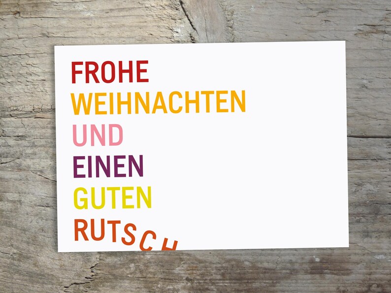 May include: A rectangular white greeting card featuring the German text FROHE WEIHNACHTEN UND EINEN GUTEN RUTSCH printed in stacked lines. The words are colored in red, yellow, pink, purple, yellow, and orange, with the final word slightly curved.