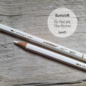 May include: White watercolor pencil with gold lettering that reads "STABILO All 8052 AQUARELLABLE". The pencil is on a light brown wooden surface. The text "Buntstif f&uuml;r fast alle Oberfl&auml;chen (wei&szlig;)" is visible in a circle above the pencil.
