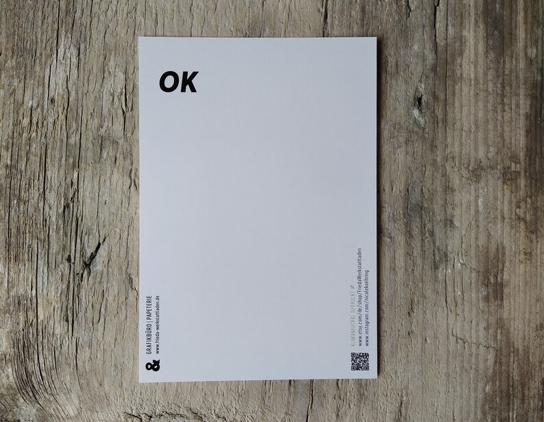 May include: White postcard with the word "OK" printed in black at the top. The bottom of the postcard has the text "GRATINHOF PAPETERIE" and a website address.
