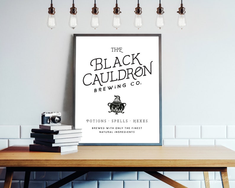 May include: A black and white poster with the text "The Black Cauldron Brewing Co." and a black cauldron with steam coming out of it. The text below the cauldron reads "Potions Spells Hexes Brewed with only the finest natural ingredients."