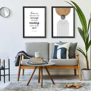 May include: A living room interior with a gray sofa, a round coffee table, a floor lamp, a potted plant, and two framed prints on the wall. The print on the left features a quote by C.S. Lewis: "Some day you will be old enough to start reading fairy tales again." The print on the right features a geometric design with a brown circle, a gray circle, and black lines.