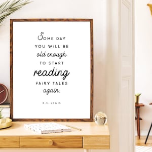 May include: A framed print with a brown wooden frame and a white background. The print features a black and white quote that reads "Some day you will be old enough to start reading fairy tales again. C.S. Lewis".