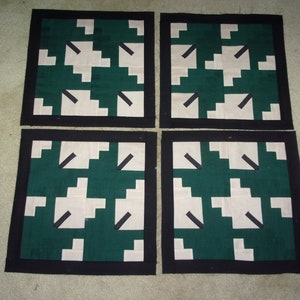 May include: Four square fabric panels with a black border. Each panel features a geometric pattern of white and green squares with black lines.