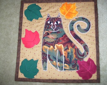 Fall cat quilt that has been machine quilted and appliqued with fall leaves