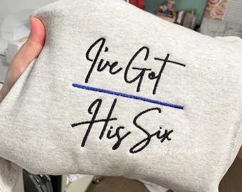 Könnte beinhalten: Grauer Sweatshirt mit schwarzem gesticktem Text, der "I've Got His Six" lautet.