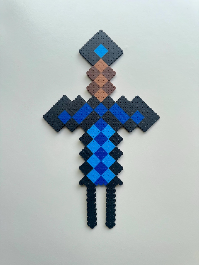 May include: A blue and black pixelated sword made of beads. The sword has a brown handle and a blue diamond at the top.