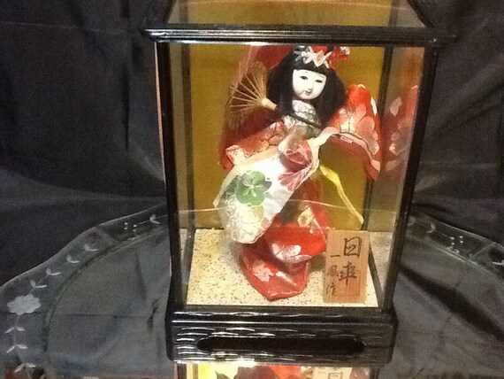 geisha doll in glass case