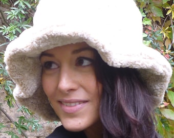 Puede incluir: Un sombrero blanco de crochet en forma de cubo con un ala ancha. El sombrero lo lleva una persona con el pelo largo y oscuro. La persona lleva una camisa negra y el texto "DongoDesign" es visible en la esquina inferior derecha de la imagen.