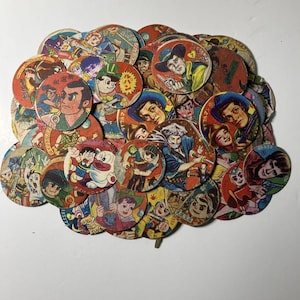 May include: A collection of vintage, circular cardboard collectibles featuring colorful illustrations of cartoon characters and figures. The images have a retro aesthetic, with a variety of designs and colors, including red, blue, and yellow.