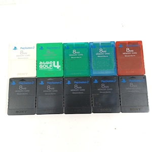 Puede incluir: Una colección de tarjetas de memoria PlayStation 2 en varios colores, incluyendo blanco, verde, azul y rojo. Cada tarjeta está etiquetada con "PlayStation 2", "8MB Memory Card" y "MagicGate". Algunas tarjetas tienen texto adicional.