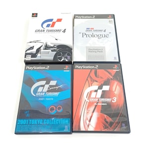 May include: Four PlayStation 2 video game cases featuring the Gran Turismo series. The cases display car graphics and the game titles "Gran Turismo 4", "Gran Turismo 4 Prologue", "Gran Turismo Concept 2001 Tokyo Collection", and "Gran Turismo 3 A-Spec".