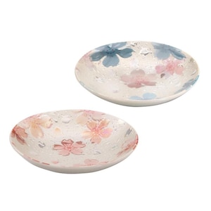 May include: Two small, round decorative dishes. Each dish has a white background with a pattern of pink and blue floral designs. The dishes have a slightly textured surface, giving them a unique appearance.
