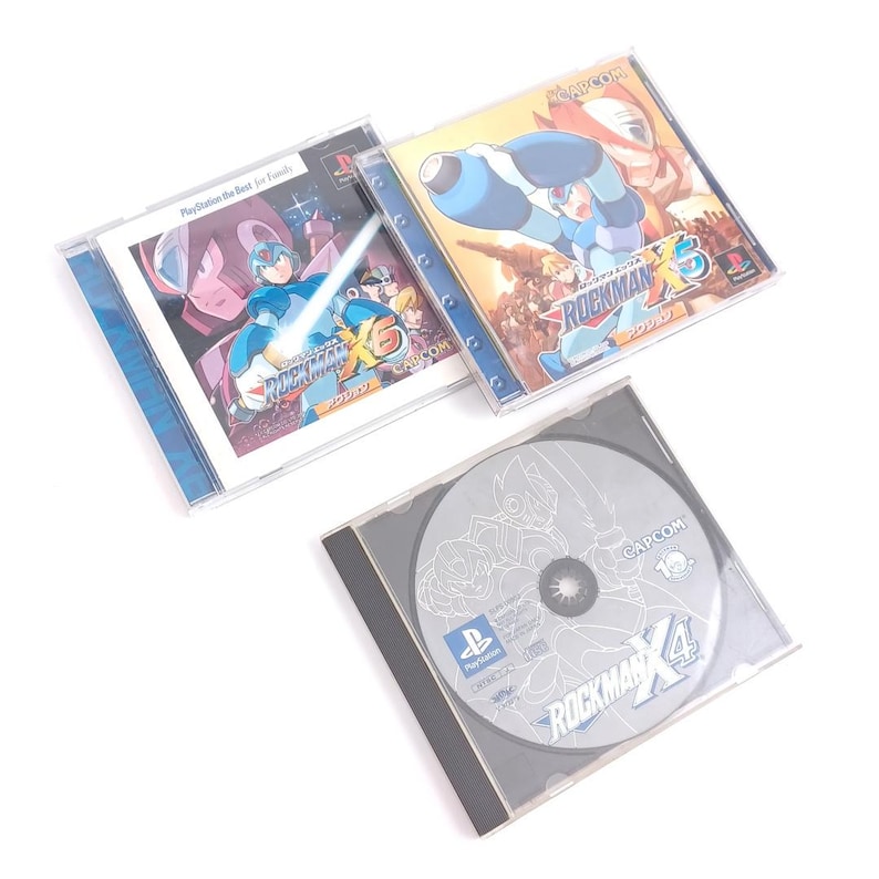 Puede incluir: Tres cajas de juegos de video para la consola PlayStation. Las cajas son azules, rojas y plateadas. Los juegos son todos de la serie Mega Man. Los t&iacute;tulos son Mega Man X4, Mega Man X5 y Mega Man X6.