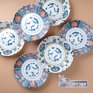Può includere: Set di sei piatti in ceramica blu e bianca con un design floreale e geometrico. I piatti presentano un cervo stilizzato e il testo "Earst Japan".
