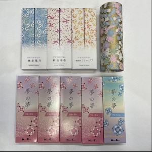 Op de afbeelding: Een assortiment Japanse wierookdozen en een rol decoratieve tape. De wierookdozen hebben bloemen- en geometrische ontwerpen in verschillende kleuren, met Japanse tekst. De taperol is versierd met een bloemenpatroon.
