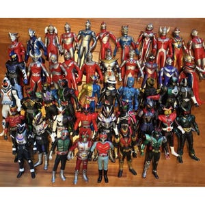 May include: A collection of colorful action figures, featuring various characters in dynamic poses. The figures showcase a range of designs, with vibrant reds, blues, and silvers. The toys are arranged closely together, creating a visually rich display.