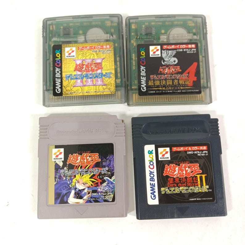 May include: Four Game Boy Color and Game Boy cartridges with Japanese text and colourful graphics. The cartridges are in various colours, including clear, grey, and black. The labels feature characters and logos.