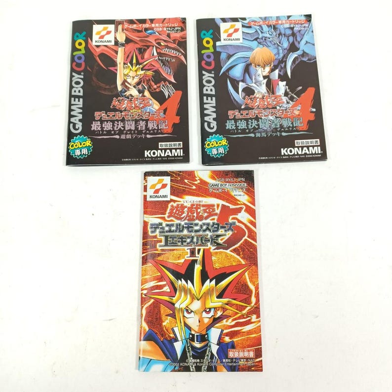 May include: Three vintage Yu-Gi-Oh! video game cartridges. Two feature the text "GAME BOY COLOR" and "デュエルモンスターズ 最強決闘者戦記". The third cartridge has the text "遊戯王デュエルモンスターズ エキスパート2".