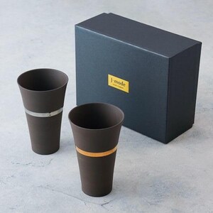 May include: Two dark brown ceramic tumblers with metallic bands, one silver and one gold, are displayed next to a dark gray box. The box has a gold label with the text "j-mode". The tumblers have a tapered design.