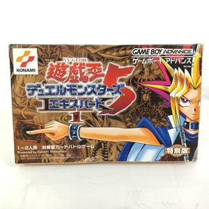 May include: A Yu-Gi-Oh! Duel Monsters 5 Expert 1 Game Boy Advance video game box. The box features a character illustration and Japanese text. The Konami logo is visible. The box is rectangular and has a brown and red colour scheme.