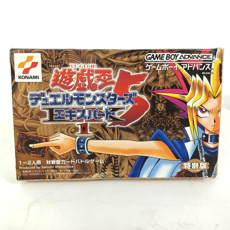 May include: A Yu-Gi-Oh! Duel Monsters 5 Expert 1 Game Boy Advance video game box. The box features a character illustration and Japanese text. The Konami logo is visible. The box is rectangular and has a brown and red colour scheme.