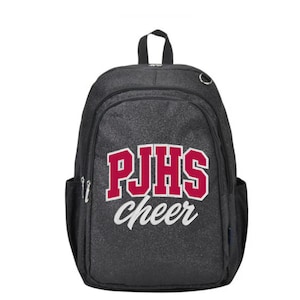 May include: A black glittery backpack featuring the red text PJHS in a bold collegiate font with the word cheer written in white cursive script below it. The bag includes a top handle, a large main compartment, and side pockets with silver zippers.