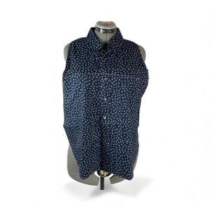 May include: A sleeveless navy blue button-down shirt with a white polka dot pattern. The shirt is displayed on a mannequin. The collar is buttoned up. The shirt has a tailored fit and a classic design.