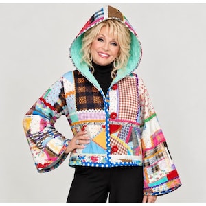 May include: A hooded jacket featuring a patchwork design with various colorful fabric patterns including plaid, floral, and gingham prints. The jacket has wide sleeves, a light blue interior lining, and three large red buttons down the front closure.