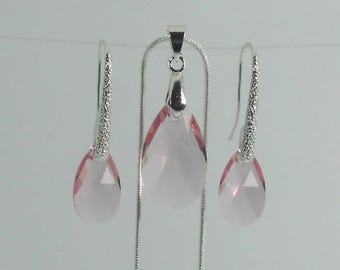 May include: A jewelry set featuring a pendant necklace and matching earrings. The set includes a silver chain necklace with a teardrop-shaped pink pendant. The earrings have a similar pink teardrop design and silver accents.