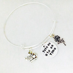 Può includere: Braccialetto in argento con un ciondolo a forma di teiera, una rosa e un ciondolo che dice "Tale as old as Time".