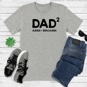 May include: Gray t-shirt with black text that reads "DAD² Aiden • Benjamin"