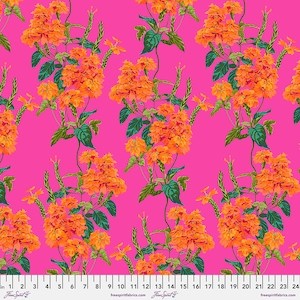 May include: A pink fabric with a repeating pattern of orange flowers and green leaves. The fabric has a ruler printed on the bottom with inches marked.