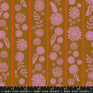 Op de afbeelding: Een bruine stof met een herhalend patroon van roze bloemen en bladeren. De stof heeft verticale strepen in oranje en wit.