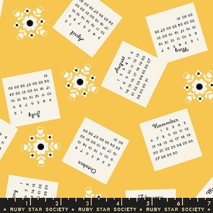 以下が含まれることがあります： 黄色い背景に、黒い文字と数字が書かれた白い正方形が並んでいます。それぞれの正方形は、年の異なる月を示しています。正方形は、白黒の花柄で飾られています。