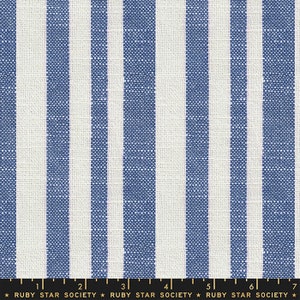 May include: White fabric with blue vertical stripes. The fabric has a textured woven look. The fabric is marked with a ruler in inches and the text "RUBY STAR SOCIETY".