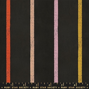May include: Black fabric with vertical stripes in orange, peach, pink, and gold. The fabric is marked with a ruler in inches and the text "RUBY STAR SOCIETY".
