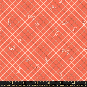 May include: A coral pink fabric with a white grid pattern and white doodle-like swirls. The fabric has a ruler with inches marked on it.