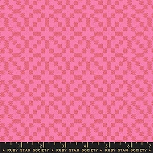 May include: Pink fabric with a small, repeating checkered pattern. The fabric has a textured surface.