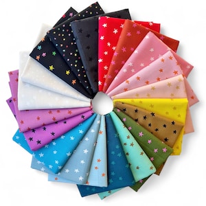 Pode incluir: Uma disposição circular de quadrados de tecido dobrados em várias cores, cada um adornado com um padrão de estrelas. As cores incluem preto, vermelho, rosa e azul. Os tecidos são provavelmente de algodão, adequados para projetos de patchwork ou artesanato.