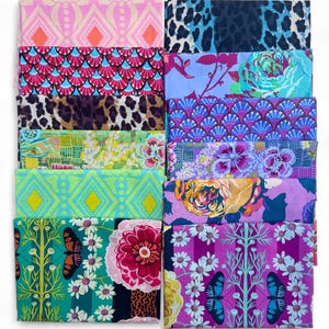 May include: A collection of folded fabric pieces with various colorful patterns. Designs include animal prints, floral arrangements, geometric shapes, and butterfly motifs. The color palette features pink, blue, green, yellow, and purple.