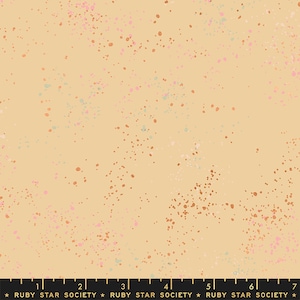 May include: A beige fabric with a speckled pattern of pink, orange, and blue dots. The fabric is a cotton blend and is perfect for quilting, sewing, and crafting.