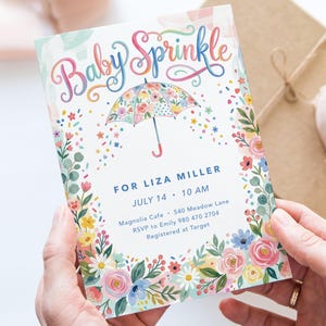 May include: A baby shower invitation with the words "Baby Sprinkle" in colorful script. The invitation features a floral umbrella design and a border of flowers. Details include the date, time, and location.