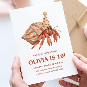 Puede incluir: Una invitaci&oacute;n de cumplea&ntilde;os con una ilustraci&oacute;n en acuarela de un cangrejo ermita&ntilde;o con un gorro de fiesta. La invitaci&oacute;n dice "&iexcl;OLIVIA TIENE 10 A&Ntilde;OS!" con detalles del evento. La invitaci&oacute;n se sostiene en las manos.